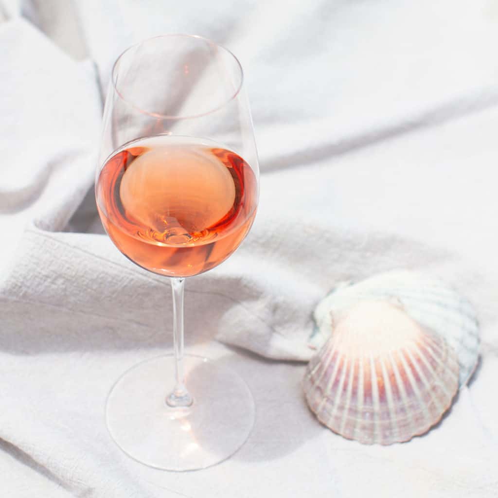 A glass of Rosé with some seashells